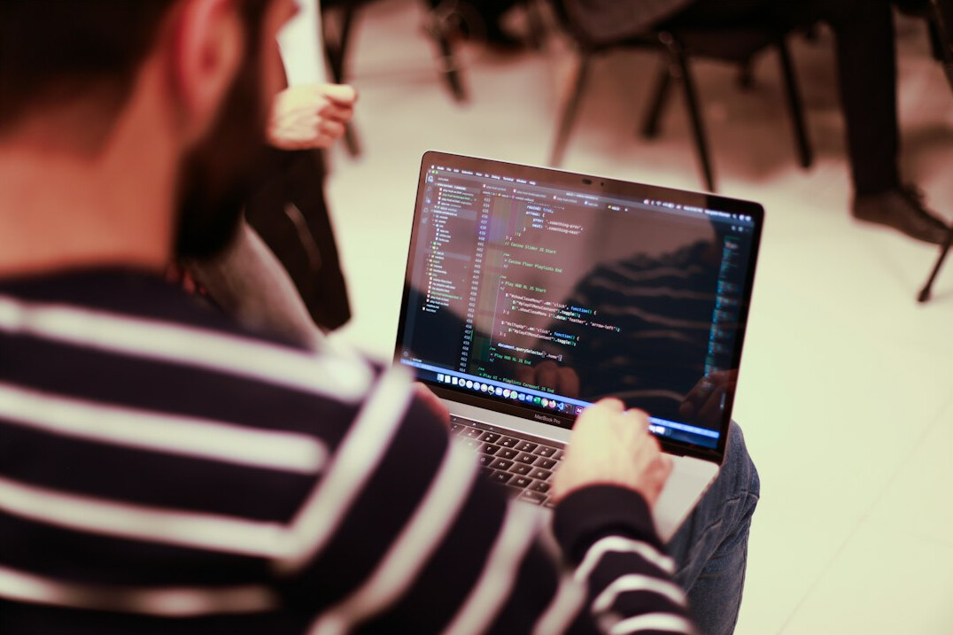 students coding on laptops