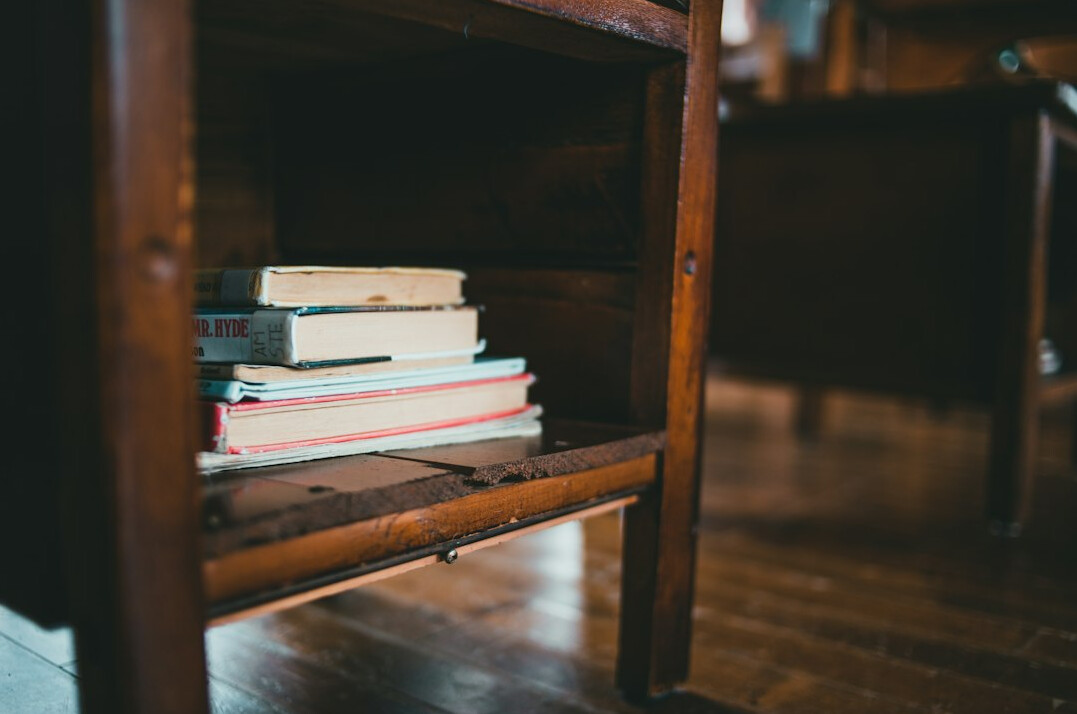 Stack of books on a wooden desk
